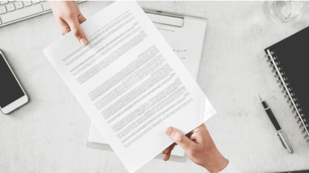Zdjęcie dokumentu i dwóch dłoni, które go trzymahą 
